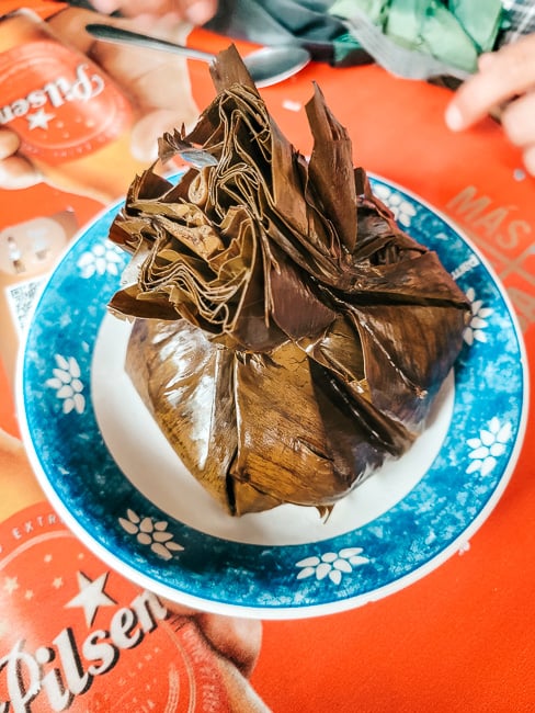 Tamales tolimenses, a traditional Colombian food made of ground corn, rice, peas, chicken and spices steamed in banana leaves.