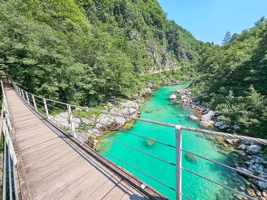 The view from the bridge with the beautiful blue water and the mountain in the background. Beautiful views along the trail like this are one of the big perks of the Slap Kozjak waterfall.