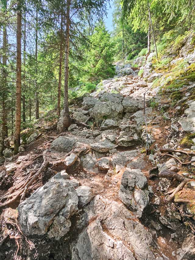 A rocky trail goes up the  mountain side.