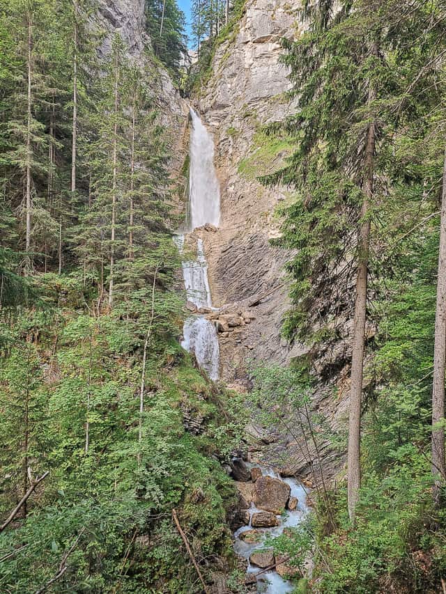 The Martuljek waterfall goes down multiple ledges and then drops down into a river.