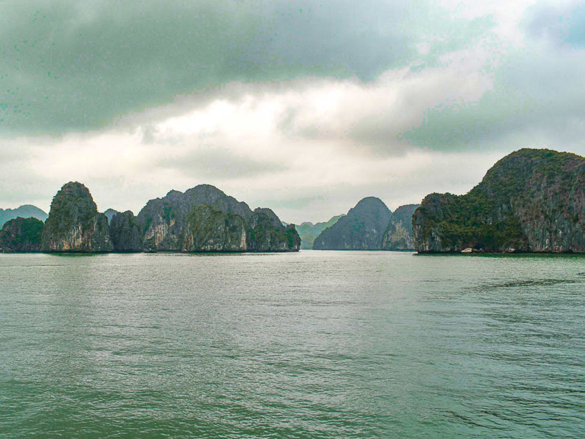 Multiple sheer rock islands scatter around in the blue and round water. 