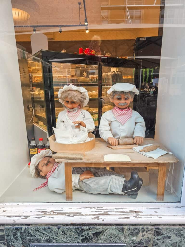 A display in a shop in the Zagreb market of 3 bakers making some bread. 